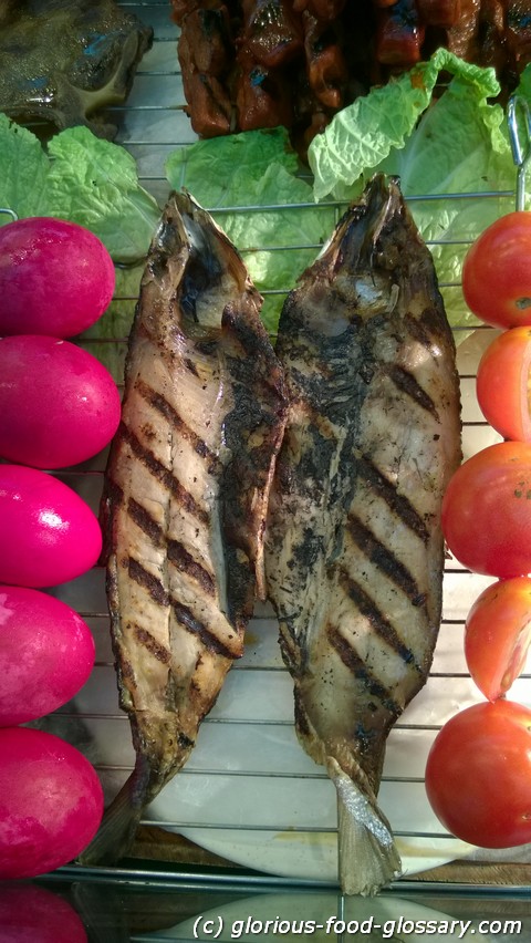 Inihaw na Bangus or Grilled Milkfish is best eaten with salad made from slices of fresh tomatoes and slices of  Itlog na Maalat (red salted eggs)
